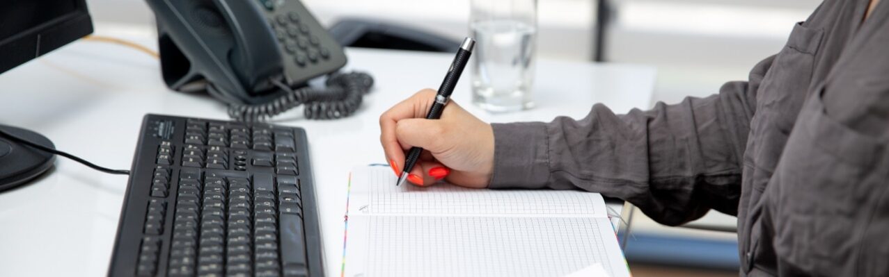 front-view-young-beautiful-businesswoman-working-her-pc-table-along-with-phone-graphics-writing-down-notes-job-activities-technology