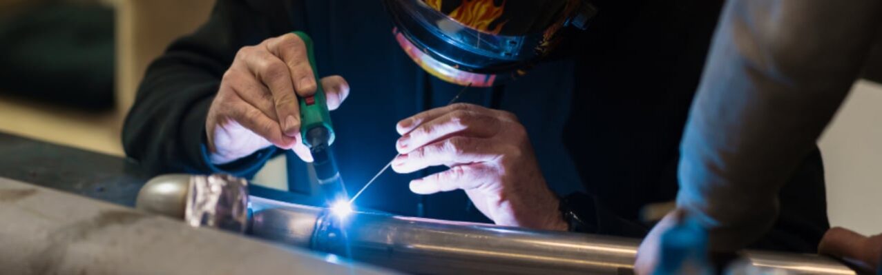 man-working-with-argon-welding-machine-garage