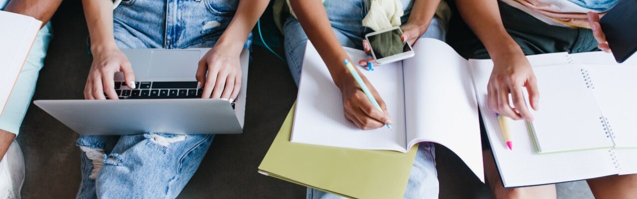 close-up-overhead-portrait-girl-blue-shirt-jeans-holding-laptop-knees-while-sitting-beside-university-mates-female-student-writing-lect.jpg