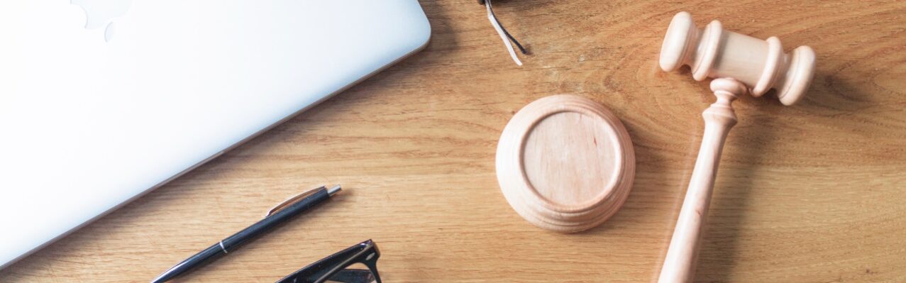 high-angle-view-laptop-spectacles-gavel-pen-wooden-background-wooden-desk.jpg