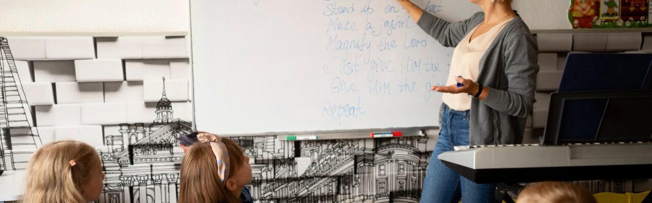 side-view-teacher-writing-whiteboard.jpg