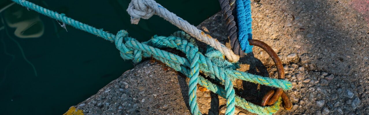 mooring-ring-with-tied-blue-white-nautical-rope-mounted-concrete-pier-marina-safety-equipment.jpg