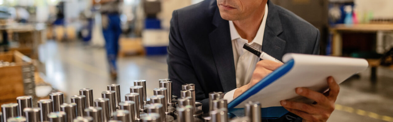 quality-control-inspector-writing-reports-while-analzying-manufactured-steel-rod-cylinders-industrial-building.jpg