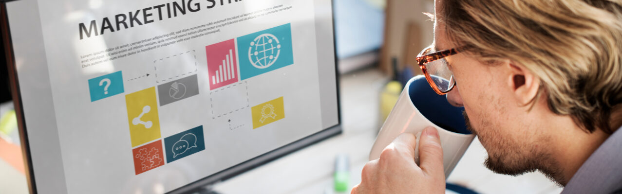 primer-plano-de-hombre-caucasico-bebiendo-cafe-con-la-pantalla-de-la-computadora-que-muestra-la-estrategia-de-marketing.jpg